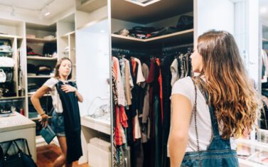 Young teenager trying out dress in front of the mirror