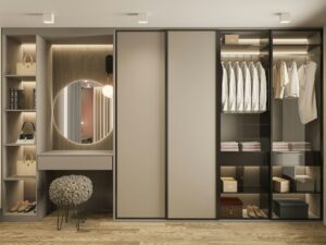 custom closet with mirror, seating, and cabinetry